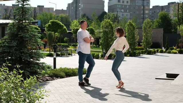 The guy and the girl turn to each other, stand with their backs turned to dance. Beautiful movement of women's hips