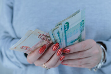 Female hands holding paper bills in Russian rubles