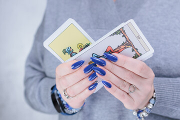 Female hands holding tarot cards for fortune telling and tricks