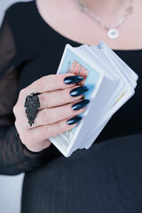Female hands holding tarot cards for fortune telling and tricks