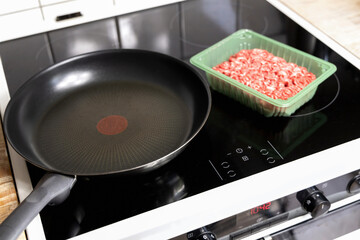 Fresh minced beef meat in plastic box ready for cooking at home in the kitchen. Homemade food concept.