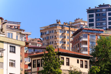 Cityscape, view of buildings and houses with green plants in public places in Turkey, sunny summer day in the city of Istanbul