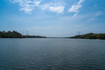 Obraz premium High voltage lines and power tower on Xingu River near Belo Monte hydro power plant in Amazon rainforest in Altamira city, Para, Brazil. Concept of environment, ecology, nature, energy, electricity. 