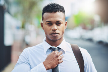 Businessman, portrait and confidence with tie in city for morning commute, travel to work and ready or serious. Professional, person or pride for corporate career, internship or employee on sidewalk