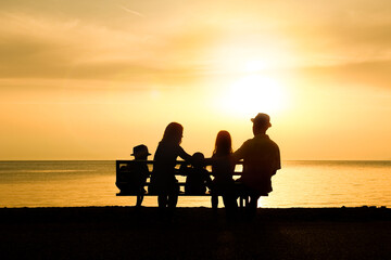 A happy family in nature by the sea on a trip silhouette