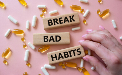 Break bad habits symbol. Concept words Break bad habits on wooden blocks. Beautiful pink background with pills. Doctor hand. Medicine and Break bad habits concept. Copy space.