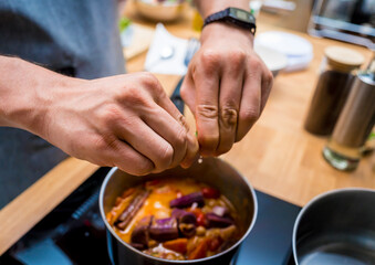 Chef at the kitchen preparing massaman curry with sweet potato and many spices