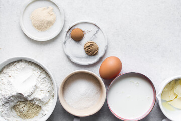 overhead view of mise en place for hot cross buns dough, ingredients for making hot cross buns on a marble countertop