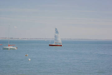 Fototapeta premium Sailboat on Calm Blue Sea with Clear Sky. Sailboat