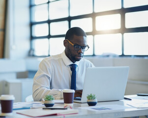 Finance, documents or African businessman with laptop in office for planning, research or tax, savings or review. Fintech, investment or accountant with glasses for startup, accounting or sale profit