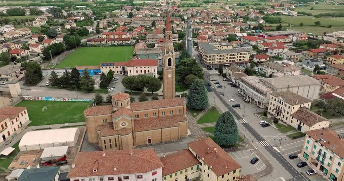 Aerial view cityscape Cornuda Italy. A beautiful cathedral in the center of the village with a bell tower in a mountain landscape. High quality 4k footage