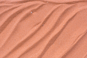 Lines drawn in coral sand background, beautiful sand texture, overhead view of brick orange sand, zen pattern drawn in the sand, Top view of fine grain texture