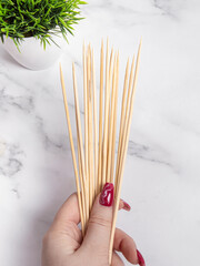 Woman holds wooden skewers. Skewers for food or creativity
