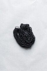 Overhead view of fresh squid ink pasta, homemade squid ink pasta, process of making fresh black pasta