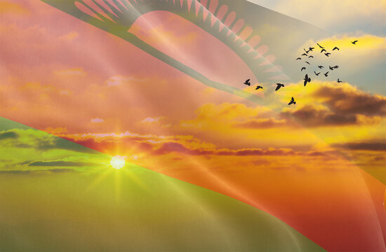 Waving the flag of Malawi against the background of a sunset or sunrise. Malawi flag for Independence Day. The symbol of the state on wavy fabric.