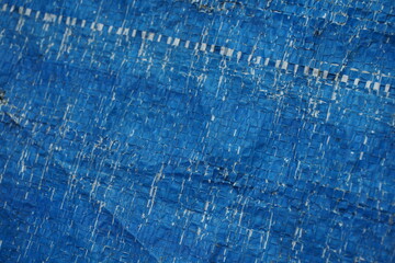 Weathered and damaged tent surface backdrop, grungy and rustic blue backdrop for presentation, cracked pattern texture background