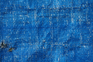 Weathered and damaged tent surface backdrop, grungy and rustic blue backdrop for presentation, cracked pattern texture background