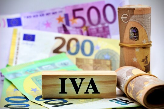 Wooden piece with the text "Iva" stand for an Italian tax with european banknotes as background.