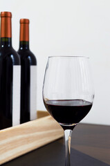 Copa de vino tinto malbec en detalle, color rojo violáceo intenso y cuerpo robusto, con fondo blanco.  