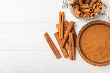 Cinnamon sticks on a textured wooden background. Cinnamon roll. Spicy spice for baking, desserts and drinks. Fragrant ground cinnamon. cinnamon powder Close-up. Place for text. copy space