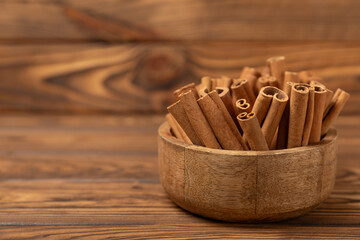 Cinnamon sticks on a textured wooden background. Cinnamon roll. Spicy spice for baking, desserts and drinks. Fragrant ground cinnamon. cinnamon powder Close-up. Place for text. copy space