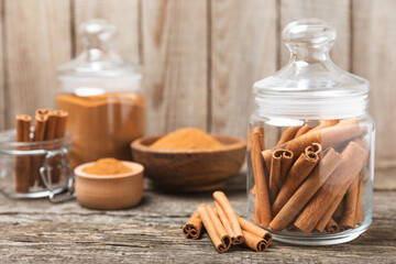 Cinnamon sticks on a textured wooden background. Cinnamon roll. Spicy spice for baking, desserts and drinks. Fragrant ground cinnamon. cinnamon powder Close-up. Place for text. copy space