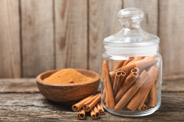 Cinnamon sticks on a textured wooden background. Cinnamon roll. Spicy spice for baking, desserts and drinks. Fragrant ground cinnamon. cinnamon powder Close-up. Place for text. copy space