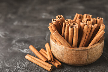 Cinnamon sticks on a textured wooden background. Cinnamon roll. Spicy spice for baking, desserts and drinks. Fragrant ground cinnamon. cinnamon powder Close-up. Place for text. copy space