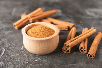Cinnamon sticks on a textured wooden background. Cinnamon roll. Spicy spice for baking, desserts and drinks. Fragrant ground cinnamon. cinnamon powder Close-up. Place for text. copy space