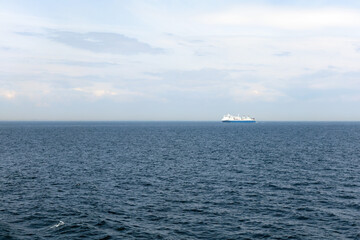 Seascape with a white ferry in the distance and waves. Sea transport