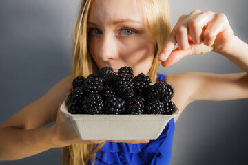 Girl holds blackberry fruits