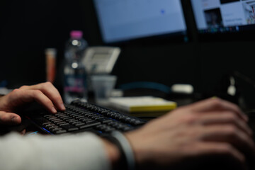 mani di un giovane uomo irriconoscibile che lavora al computer, in ufficio
