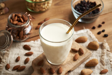 A glass of vegan almond milk with raisins with an ecological stainless steel straw