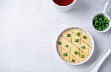 Asian steamed eggs in a bowl with soy sauce and scallions