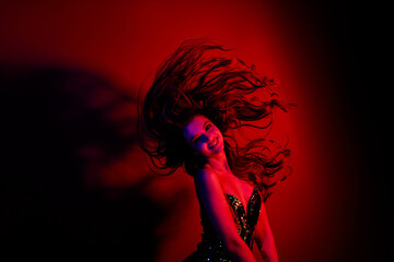 Photo of gorgeous young lady throw flying hair wear dress isolated on red blue color neon background