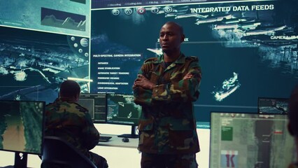 Portrait of national guard commander dressed in military camouflage uniform, team leader overseeing operations in control center. Army officer works on missions at federal agency base. Camera B.