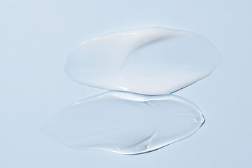 Liquid cream and gel cosmetic smudge drops texture on blue background. cosmetic smears cream texture