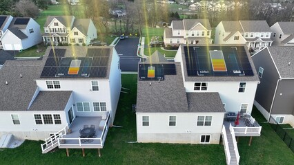 Suburban homes with solar panels on rooftops, sun rays and battery with data analytics. 3D Graphic, aerial