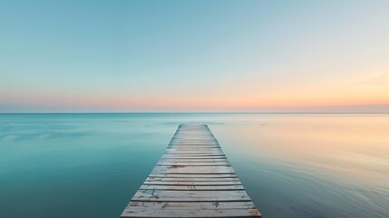Obraz premium Serene pier extending into calm blue sea at sunset. Perfect image for desktop background or inspirational quotes. Stunning minimalistic design showing peaceful nature