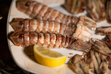 antipasto di pesce fresco a base di canocchie e sardelle condite con del limone