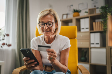 Mature senior woman buy online with credit card and on mobile phone at home