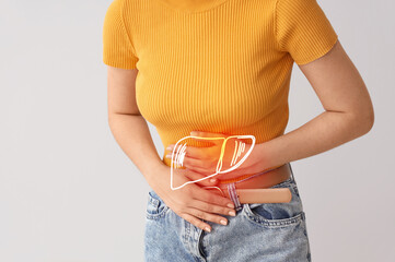 Young beautiful woman suffering from abdominal pain on grey background, closeup
