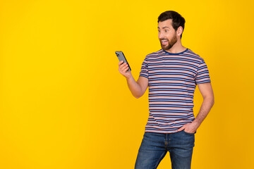 Portrait of overjoyed guy with bristle wear striped t-shirt look at smartphone read email isolated...