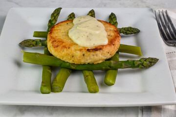 salmon burger  with tarter sauce and  asparagus