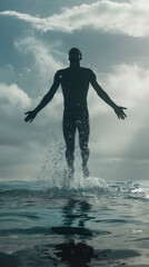 A silhouette of a man emerging from the ocean with his arms outstretched. The water splashes around him, and the sky is cloudy