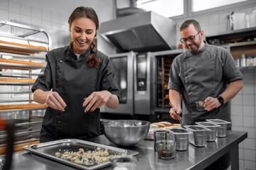 Man and woman preparing French baguettes in kitchen