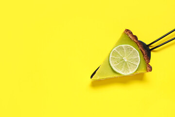Spatula with piece of tasty lime tart on yellow background
