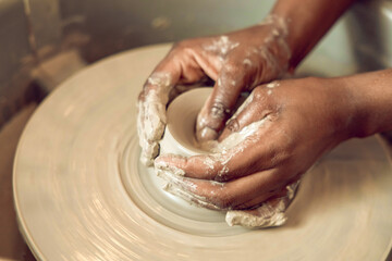 Close up of hands on a pottery wheel