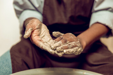 Close up of a person working with wet clay