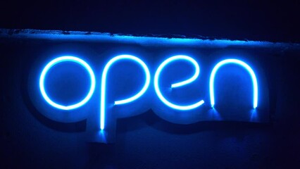 Blue neon sign changing brightness with inscription Open. Neon - chemical element, inert gas, it has symbol Ne and atomic number 10. It is the second noble gas in periodic table